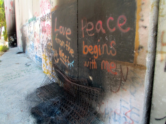 "Peace begins with me" written above what is left of a burned mattress